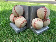 three baseballs are stacked on top of each other in the middle of some grass