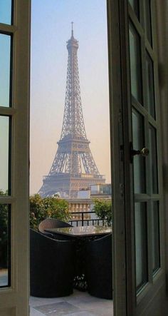 the eiffel tower is seen through an open door in front of a balcony