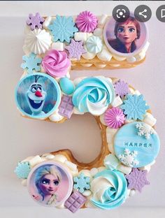 the number five is decorated with cookies and icing to look like frozen princesses