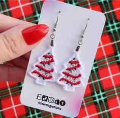 a pair of red and white christmas tree earrings