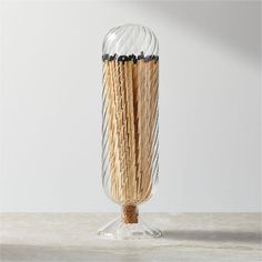 a glass vase with some sticks sticking out of it's sides on a table