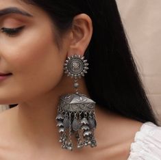 Give your ethnic look a perfect finish with Vastrabhushan's tribal banjara antique earrings. These unique boho earrings are handmade with love and expertise, just for you. These minimal oxidized silver earrings with quintessential cute little silver chimes are a beautiful ornate masterpiece engraved with extraordinary detailing that will do justice to your outfit and make you shine anywhere you go. You can preferably wear these to weddings, birthday parties, or any other occasion. Also, these In Antique Jhumka, Oxidised Jewelry, Oxidized Jewellery, Oxidized Silver Earrings, Earrings Big, Jewellery Gifts, Black Polish, Indian Earrings, Silver Jewelry Fashion