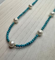 Pearl and turquoise necklace with mini gold beads in each side of the pearls. A total of 5 freshwater pearls. Necklace length is approximately 17 inches with a 2 inch extender. Turquoise Beaded Pearl Necklace, Turquoise Necklaces With Pearl Chain And Round Beads, Turquoise Necklace With Pearl Chain And Round Beads, Handmade Turquoise Pearl Beaded Necklaces, Turquoise Pearl Beaded Necklaces With Pearl Chain, Turquoise Pearl Necklace With Gemstone Beads, Turquoise Pearl Beaded Necklace Gift, Turquoise Necklace With Round Pearl Beads, Turquoise Beaded Pearl Necklaces With Pearl Chain