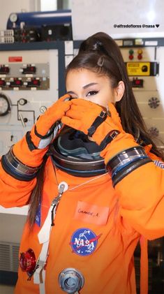 a woman in an orange space suit covering her face