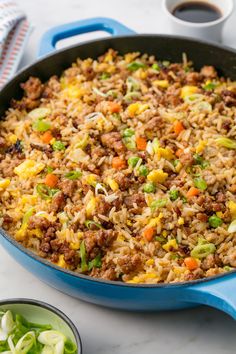 a blue skillet filled with rice and vegetables