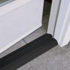 a black door mat is next to a white door