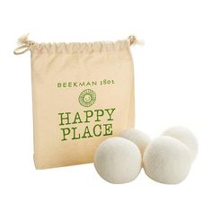 three white balls sitting next to a bag with happy place written on it and the words beekman 1080