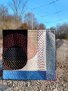 two quilts are sitting on the ground next to each other, one is black and one is blue