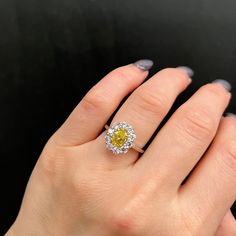 a woman's hand with a yellow and white diamond ring