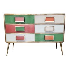 a multicolored chest of drawers with metal legs