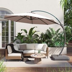 an outdoor living area with couches, tables and umbrellas