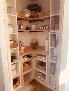 an open pantry with lots of shelves and baskets on the bottom shelf, filled with food