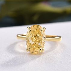 a yellow diamond ring sitting on top of a table