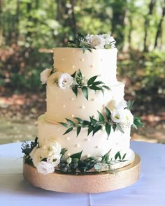 a wedding cake with white flowers and greenery