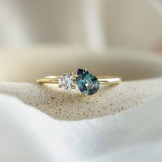 three stone ring sitting on top of a white cloth