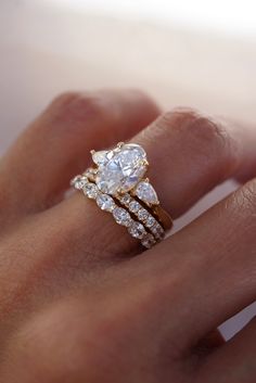 a woman's hand with two rings on it and a diamond ring in the middle