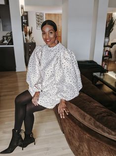 a woman sitting on top of a brown couch