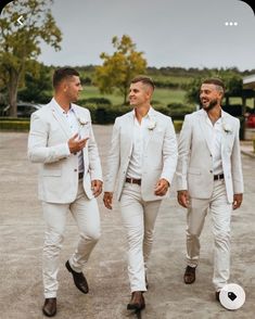 three men in white suits are walking together