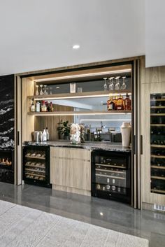 a kitchen with marble counter tops and wine racks on the wall, along with an open door that leads to another room