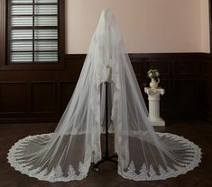 a white wedding veil on top of a mannequin in front of a window