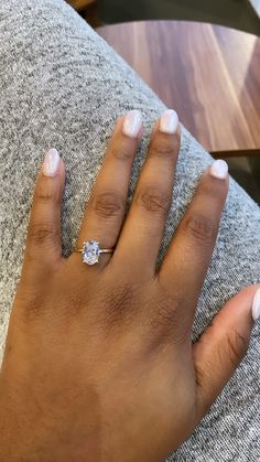 a close up of a person's hand with a diamond ring on their finger