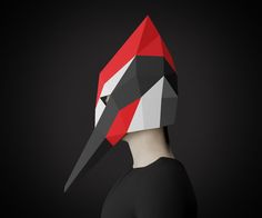 a person wearing a red and black mask with a long beak on it's head