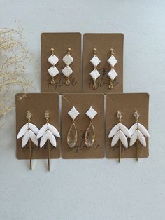 four pairs of earrings are displayed on a card