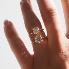 a woman's hand with two rings on it and one is holding the other