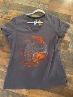 This Harley Davidson tee is a classic womens' v-neck.  Graphic on the front, in shades of orange and grey, with a bit of spakle. Smaller logo o the back from Effingham, IL.  This soft tee will soon becomone one of your favorites. Vintage Harley Davidson. #vintage #cutoffs #womenstee #summerfun #harleydavidson #motocyle #ridefast #ridefree DETAILS Size: XL Color: grey Details:  v-neck; graphic with glitter on the front; location logo on back OUR GUARANTEE If for any reason you're unhappy with your purchase, please return it to us for a full refund within 7 days. Harley Shirts For Women, Harley Davidson Tops For Women, Harley Davidson Vintage, Oversized Harley Davidson Shirt, Harley Davidson Tank Tops, Harley Davidson Vintage Tee, Harley Davidson Tee, Harley Davidson Clothing, Harley Davidson T Shirts