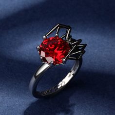 Perfect for Halloween, and cool all year long, our spider ring in Hug Me® collection is an edgy pick! This fabulous spider has long been a symbol of creativity and is seen as the master of it's own destiny. Crafted in sterling silver, this ring features a shimmering red round-cut stone hugged by a black spider. You will find more adorable and creative designs in our Hug Me® collection.Carat Weight: 6.46 ctStone Size: 10 mmStone Type: Jeulia® StoneNumber of Stones: 1 Stone Shape: RoundStone Color: Garnet RedCarat Weight: 0.057 ctStone Size: 1.5 mmStone Type: Jeulia® StoneNumber of Stones: 2 Stone Shape: RoundStone Color: Diamond WhiteWeight: 6.12 gMaterial: 925 SilverPlating Color: Silver, Black Red Rings For Halloween Gift, Unique Black Halloween Rings, Red Halloween Ring, Red Ring Jewelry For Halloween, Unique Black Rings For Halloween, Elegant Black Jewelry For Cosplay, Spider Ring, Widow Spider, Black Widow Spider