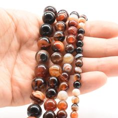 a hand holding several different colored beads