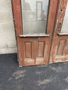 an old wooden door with two glass panels on the front and side doors are missing