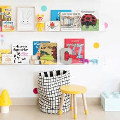 children's books are displayed on the wall in this playroom