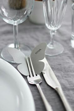 a table set with silverware and butterfly shaped utensils