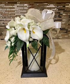 a vase filled with white flowers on top of a counter