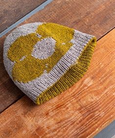 a knitted hat sitting on top of a wooden table