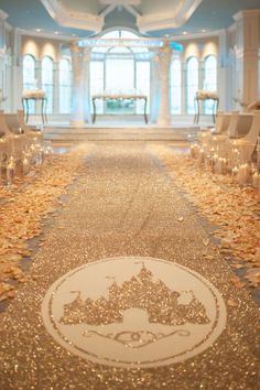 the aisle is decorated with white chairs and lit candles in front of large chandeliers