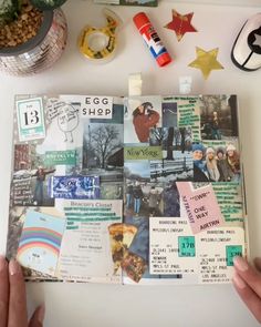 an open scrapbook with pictures and magnets on it, surrounded by other items