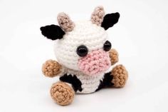 a small crocheted cow sitting on top of a white surface