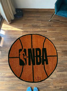 a basketball rug with the word'nba on it and blue shoes next to it