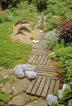 an image of a garden path made out of wood planks and rocks, with the words garden photos above it