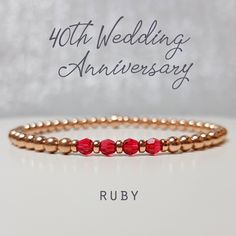 "An elegant and dainty stacking bracelet in Rose Gold Fill accented with Rubies which are the traditional gift to celebrate a 40th wedding anniversary. This Ruby and Gold stretchy layering bracelet is a lovely and subtle way to celebrate a very special 40th Ruby Wedding Anniversary with three Ruby Swarovski Crystals, one to represent and celebrate each amazing decade spent together. Also included will be a jewellery card showing the special anniversary and the meaning behind the four crystals as shown on the product images. All the beads on this bracelet are rose gold filled and the round beads are 4mm, the crystals are genuine Swarovski with amazing sparkle and are also 4mm. The beads are strung on stretchy high quality jeweller's elastic. The bracelet is sized to fit most wrist sizes aro Classic Rose Gold Bracelets For Anniversary, Adjustable Birthstone Beaded Bracelets For Anniversary, Classic Wedding Bracelets, Classic Bracelets For Wedding And Mother's Day, Anniversary Rose Gold Stackable Bracelets, Classic Wedding Bracelets For Mother's Day, Elegant Wedding Beaded Bracelets With Birthstone, Anniversary Stackable Rose Gold Bracelets, Elegant Beaded Bracelets With Birthstone For Wedding