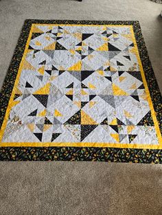 a yellow and black quilt on the floor