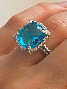 PREVIOUSLY USED  David Yurman CHATELAINE COLLECTION  14mm Blue Topaz & Diamond RingSize 7  Specifications  Estimated Retail $1800  Metal : High Polish 925. Sterling Silver  Gem: Blue Topaz 14mm  X 14mm Checkerboard Faceted Cushion Shape Diamonds: Round Brilliant, Pave Setting, Near Colorless SI clarity Estimated .30ct -.35ct Total  Signature: Inside The Band (c) DY Hallmark: 925 Condition: Very Good Collateral : Pouch  Guarantee : YES 100% Topaz And Diamond Ring, Buckle Bracelet, Chatelaine, Pave Setting, Blue Band, Multi Stone Ring, The Band, Multi Stone, David Yurman