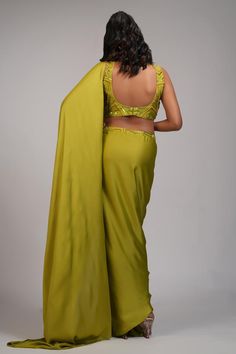 Mustard green pre-draped saree with pearl, sequin embroidery on waistband. Paired with geometric embroidered padded blouse.
Components: 2
Pattern: Embroidery
Type Of Work: Pearl, sequin
Neckline: Round
Sleeve Type: Sleeveless
Fabric: Saree: Modal Satin, Blouse: Silk
Color: Green
Other Details: 
Back deep U neck blouse
Approx weight: 5-7 kgs
Model height: 5ft 9inches, wearing size M
Occasion: Sangeet - Aza Fashions U Neck Blouse, Pearl Saree, Satin Embroidery, Draped Saree, Mustard Green, Padded Blouse, Drape Saree, Blouse Silk, Sequin Embroidery