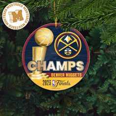 a christmas ornament hanging from the side of a tree with a basketball trophy on it