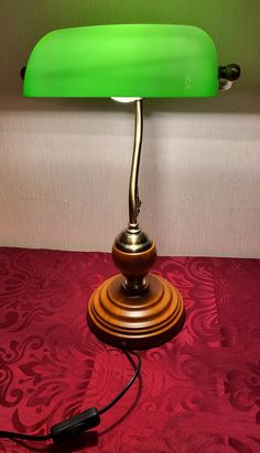 a green lamp sitting on top of a red carpeted floor next to a wall