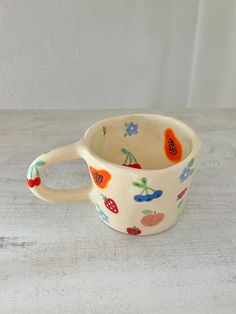 a ceramic cup with fruit designs on it