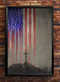 a cross on top of a hill with an american flag painted on it in front of a brick wall