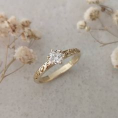 a close up of a ring on a table with flowers in the background and snow